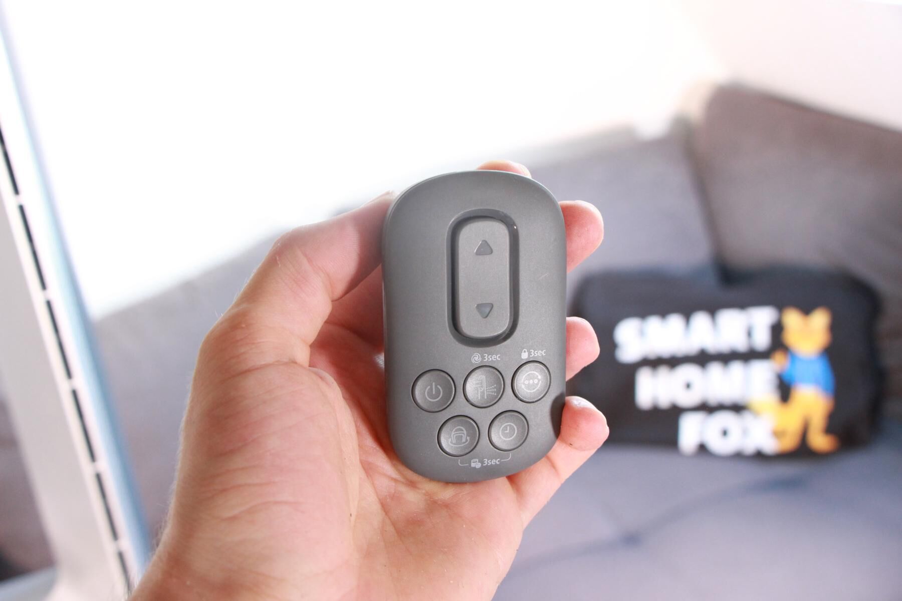 Die Fernbedienung des Philips Air Performer 8000 wird in der Hand gehalten.